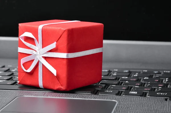 笔记本电脑键盘上的红色礼品盒 — 图库照片