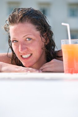 Close up of pretty woman with wet hair in swimming pool with coc