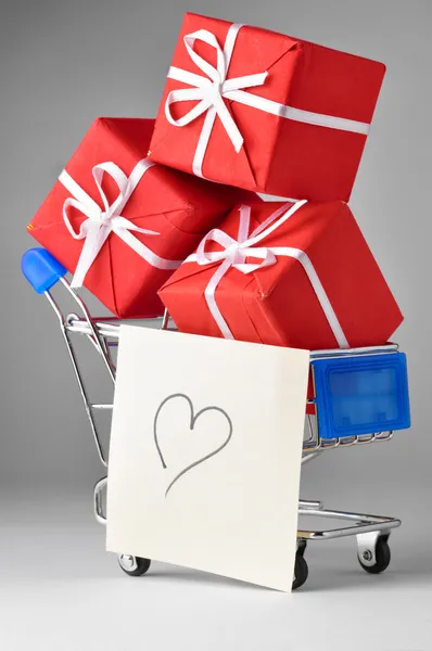 Vértes egy bevásárlókocsi, ajándékot és a szív — Stock Fotó