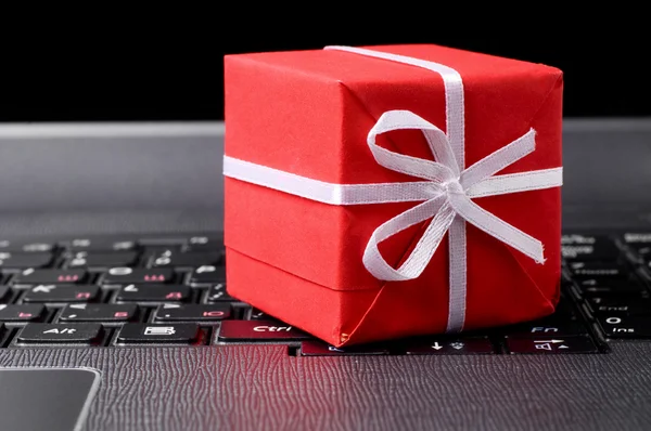 Red gift box on a laptop keyboard — Stock Photo, Image