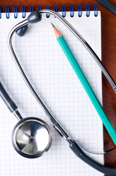 Stethoscope with pen on a notepad — Stock Photo, Image