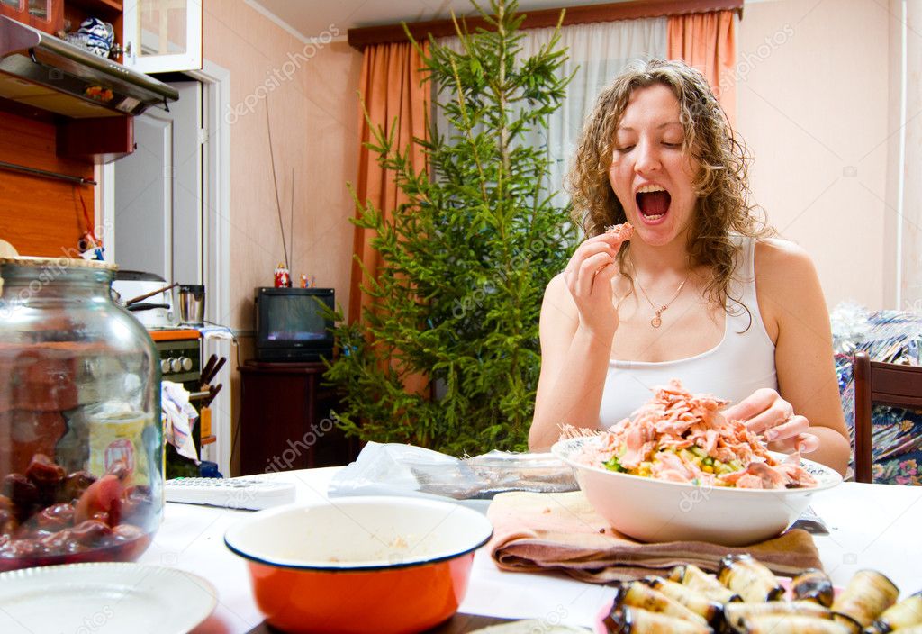 young woman is cooking holiday food and tasting it