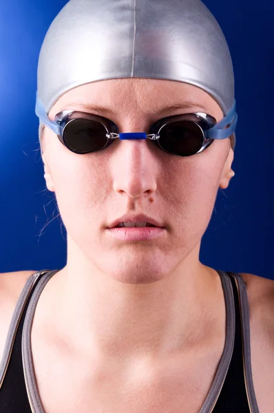 看着相机女子游泳运动员在蓝色背景上的肖像 — 图库照片