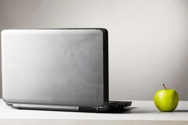 Laptop com maçã fresca verde — Fotografia de Stock