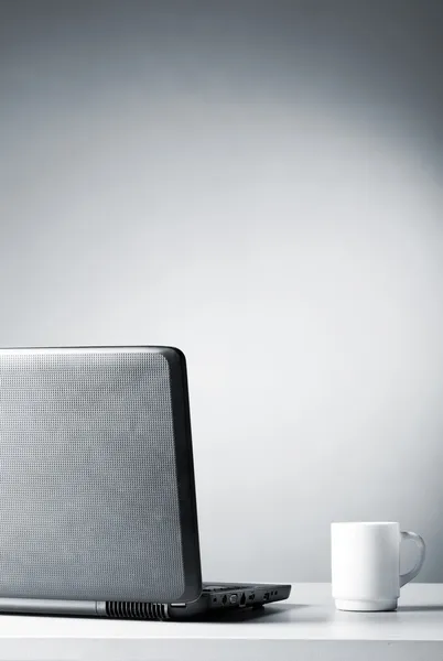 Laptop com copo branco — Fotografia de Stock