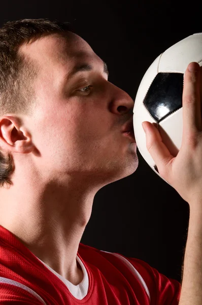 Jogador de futebol está beijando a bola — Fotografia de Stock