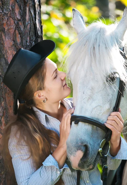 Jovem senhora abraçando seu cavalo — Fotografia de Stock