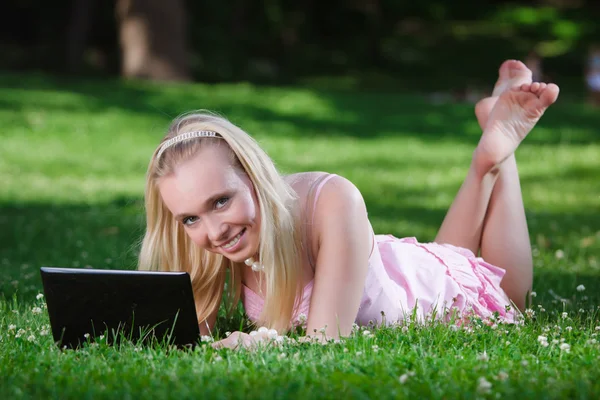 Mladá žena pomocí notebooku v parku — Stock fotografie