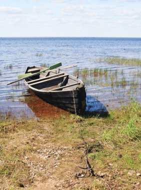 Old wooden boat on lake bank, north Russia clipart