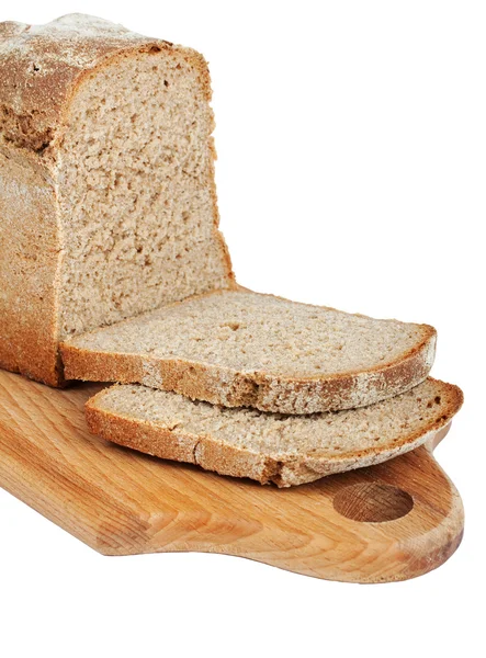 Нарежьте буханку хлеба на доске — стоковое фото