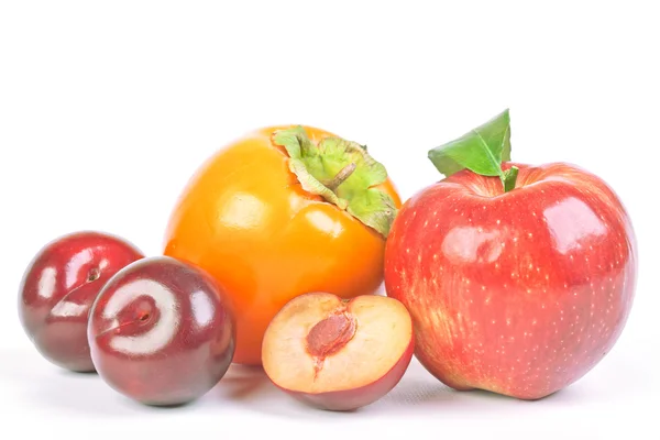 Plums, persimmon and red apple — Stock Photo, Image