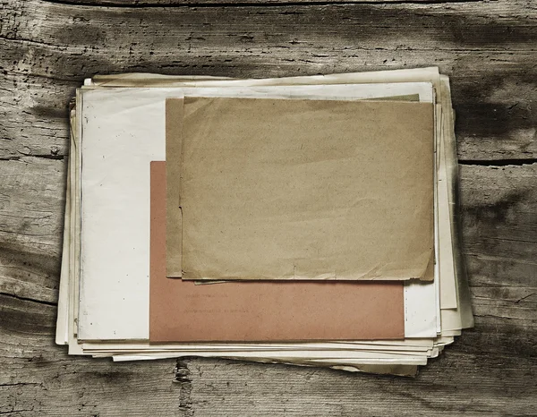 Staré papíry na dřevěné pozadí — Stock fotografie