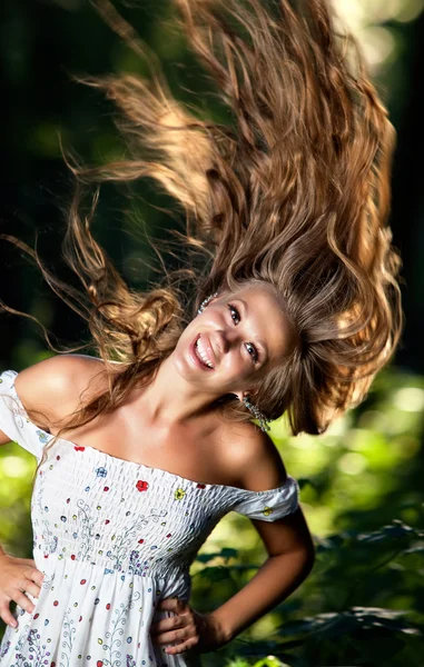 年轻女子微笑着飘飘的头发 — 图库照片
