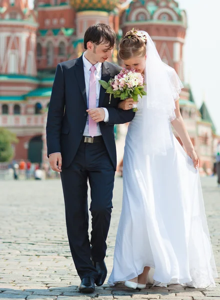 Kırmızı Kare Üzerinde Yürüyen Genç Düğün Çifti — Stok fotoğraf