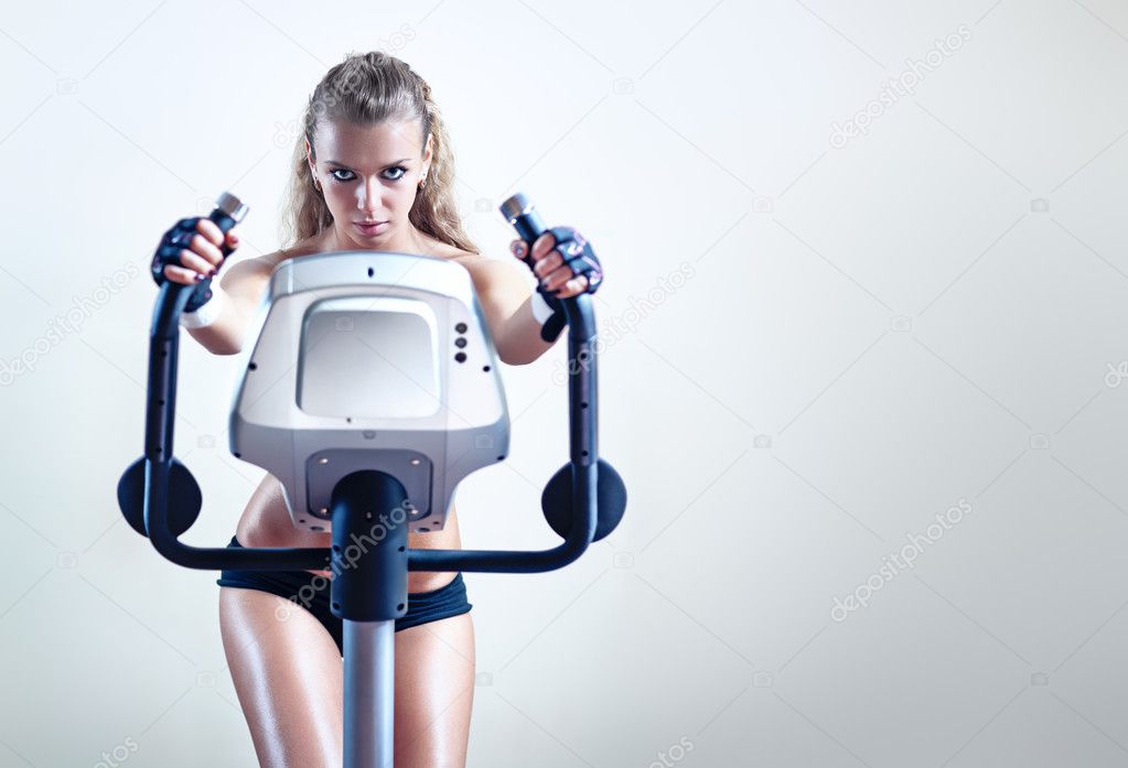 Young woman on exercise bicycle