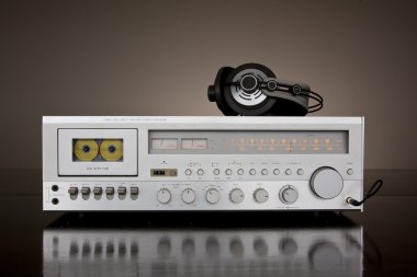 Vintage Stereo Receiver With Headphones on the dark background and a reflection clipart