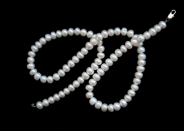 Bílé perly na černém sametu — Stock fotografie