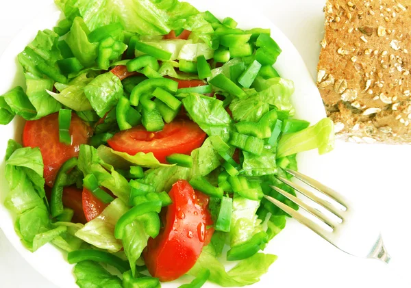 Здоровый вегетарианский салат и хлеб на белой тарелке — стоковое фото