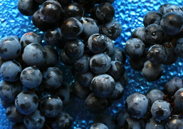Niebieski klastrów Izabela winogron na szklaną płytkę — Zdjęcie stockowe