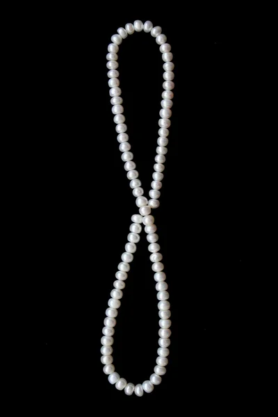 White pearls on the black silk as background — Stock Photo, Image