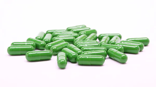 Pilules vertes sur fond blanc — Photo