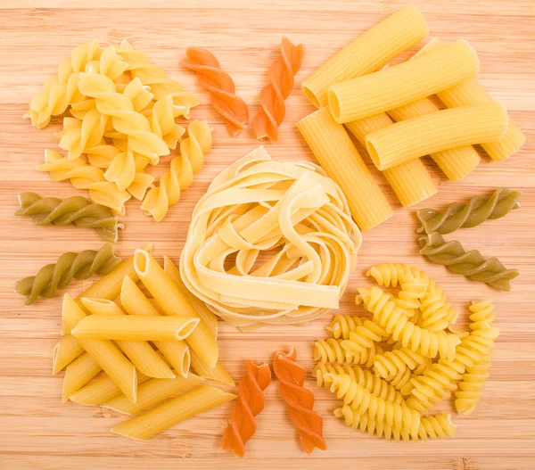 Diversi tipi di pasta italiana sullo sfondo in legno — Foto Stock