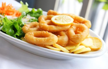 Deep batter fried squid rings calamari with green salad clipart