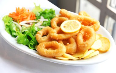 Deep batter fried squid rings calamari with green salad clipart
