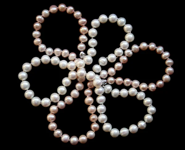 Flor de perlas blancas y rosadas sobre una seda negra — Foto de Stock