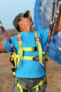 The glider pilot prepares for flight on a paraplane clipart