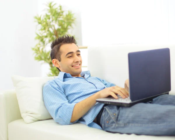 Un homme souriant avec un ordinateur portable regarde en arrière — Photo