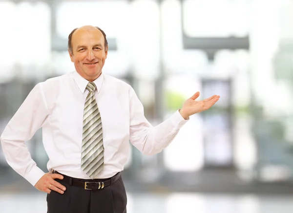 Portret van een gelukkig zakenman, iets waarop met de palm van de hand agai — Stockfoto