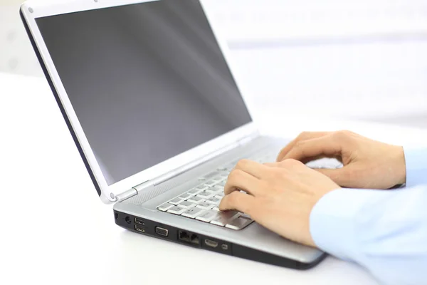 Person tippt in einem Büro auf einem modernen Laptop — Stockfoto