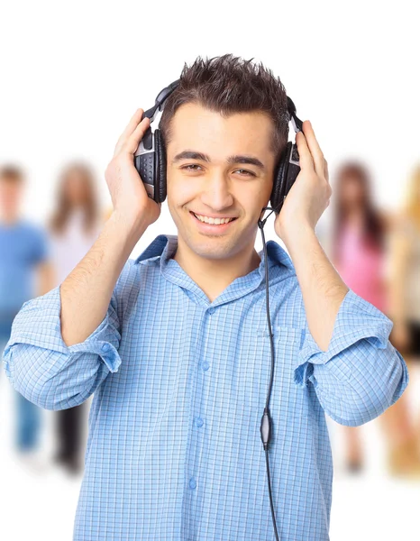 Portrait of a happy young guy listning to music against white background — Stock Photo, Image