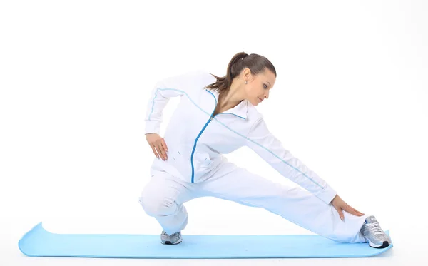 Frau macht Stretching auf einer Matte — Stockfoto