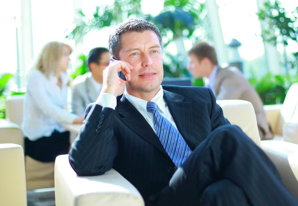 Zakenman spreken op de telefoon terwijl in een vergadering — Stockfoto