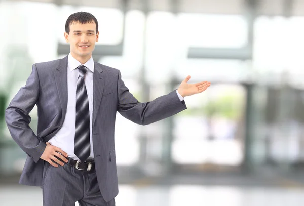 Homem de negócios feliz mostrando algo na palma da mão — Fotografia de Stock