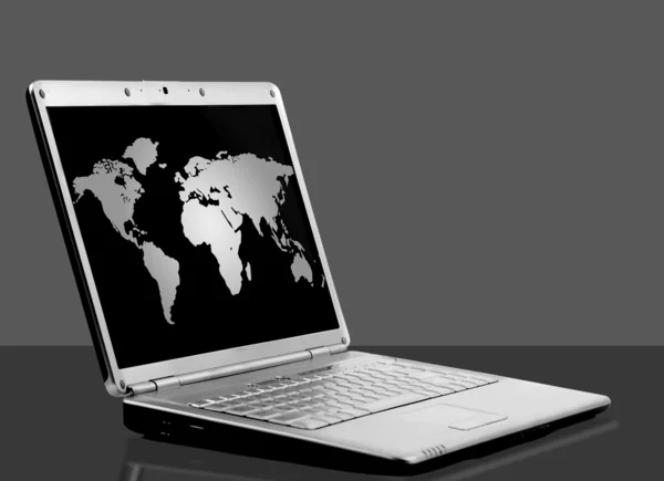 Laptop com mapa do mundo em fundo preto — Fotografia de Stock