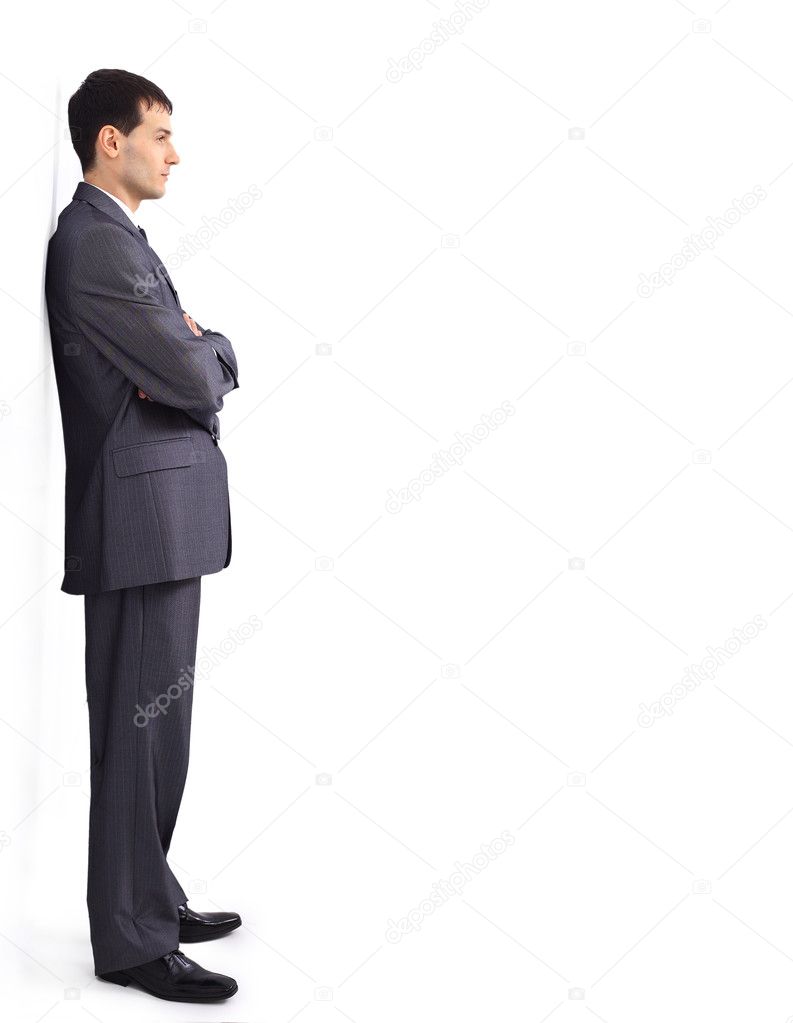 Cheerful young businessman leaning against wall