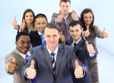 Business approval - Portrait of confident young colleagues with thumbs up s clipart