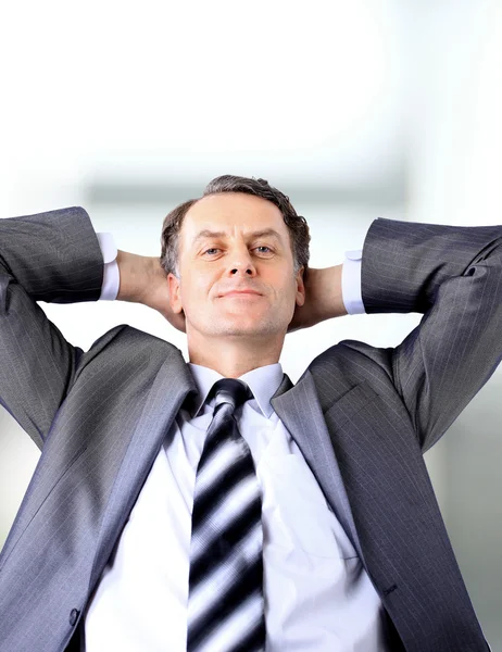 Entspannter und träumender Geschäftsmann sitzt auf Bürostuhl — Stockfoto