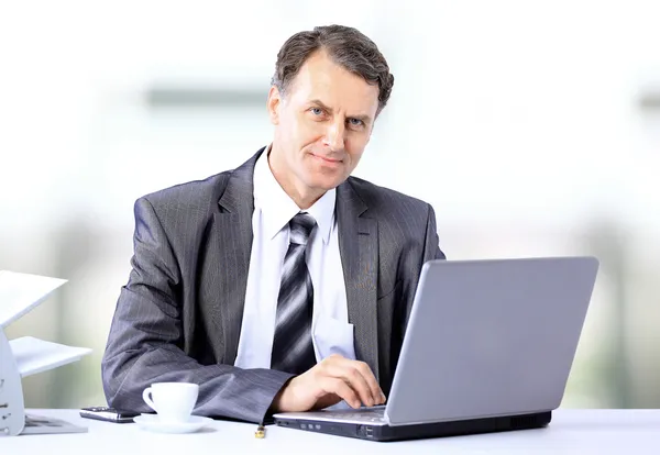 Бизнесмен, сидящий за столом и работающий с ноутбуком . — стоковое фото