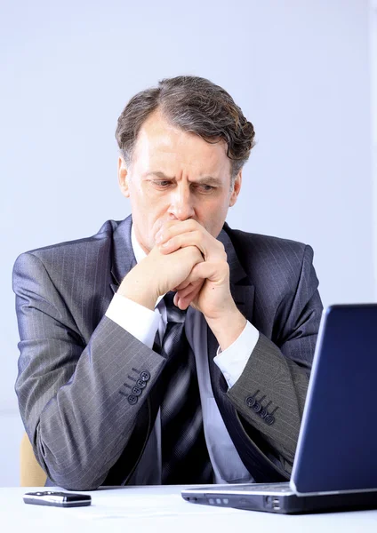 Tankeväckande affärsman tittar på sin laptop — Stockfoto