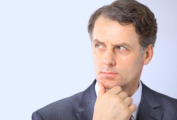 Closeup portrait of a handsome business man contemplating over a background — Stock Photo, Image