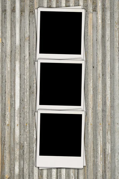Três fotos em branco sobre fundo de madeira — Fotografia de Stock