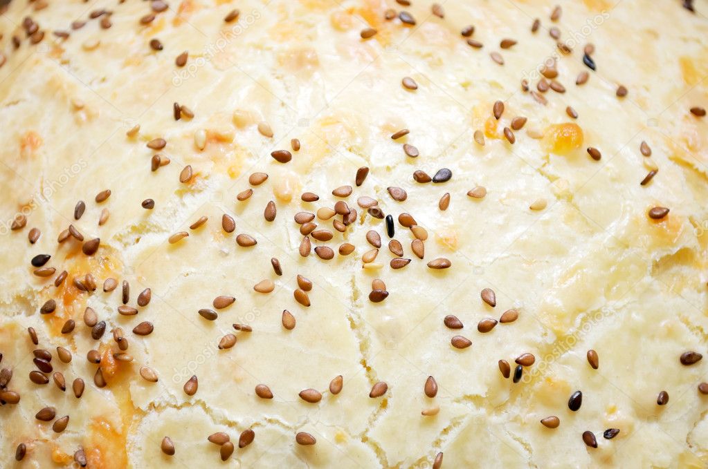 The top of a homemade cake with tan sesame seeds
