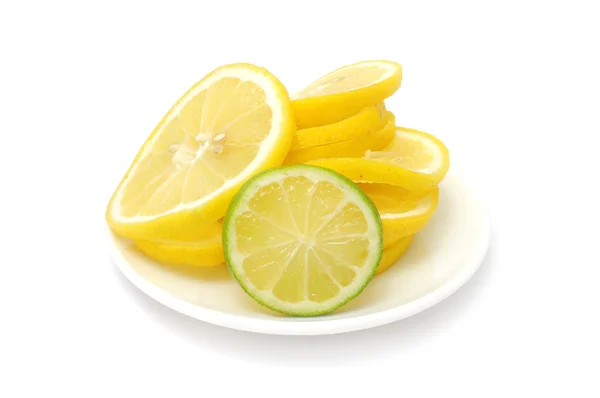 Zitrone und Limette in Scheiben geschnitten auf Teller — Stockfoto
