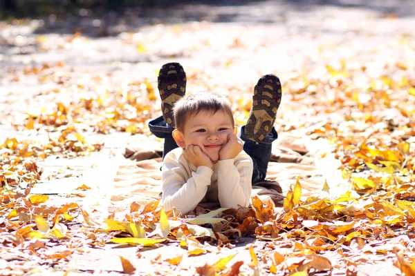 黄金葉の上に横たわる子 — ストック写真