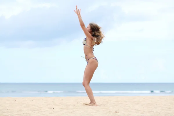 Donna in piedi su una spiaggia e godersi il sole — Foto Stock
