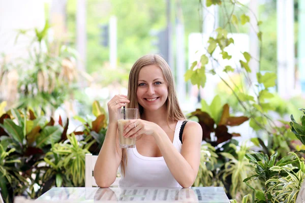 Νεαρή γυναίκα πίνοντας καφέ σε μια καφετέρια σε εξωτερικούς χώρους — Φωτογραφία Αρχείου